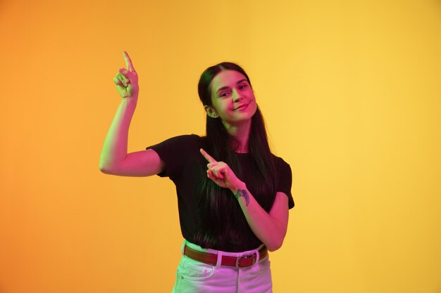 Caucasian young woman's portrait isolated on studio background in neon light. 