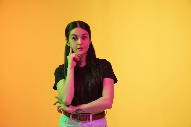 Caucasian young woman's portrait isolated on studio background in neon light. 