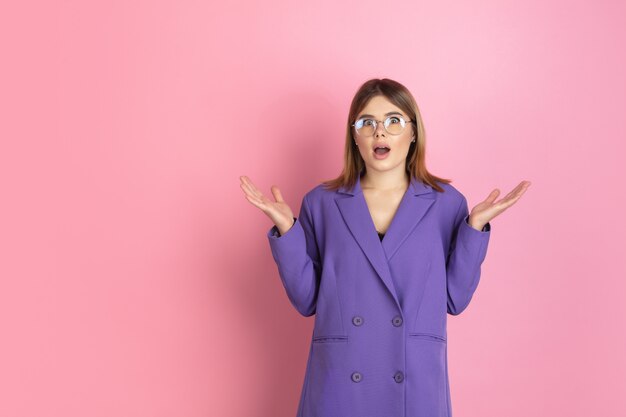 Caucasian young woman's portrait on pink, emotional and expressive