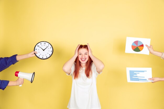 Free Photo caucasian young woman's portrait on yellow background, too much tasks