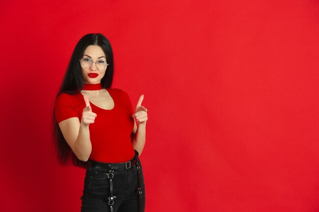 Caucasian young womans monochrome portrait on red  wall emotional and expressive