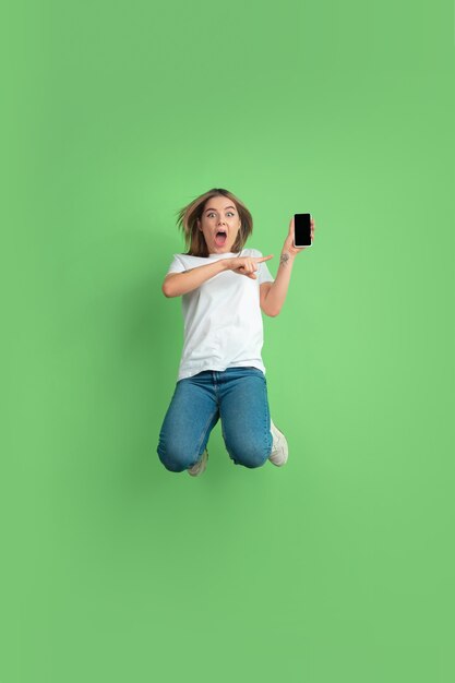 Caucasian young womans portrait on green studio wall