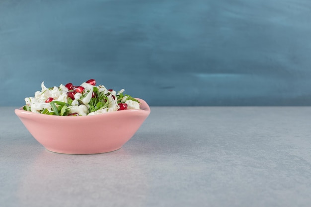 Cauliflower salad with red pomegranate seeds in a plate.