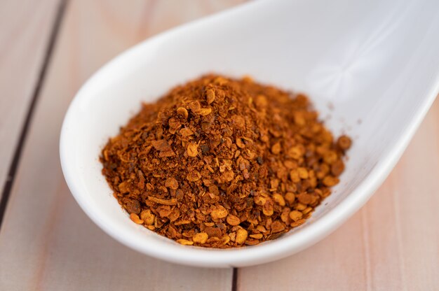 Cayenne pepper in a cup on the wooden floor.