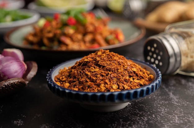 Cayenne pepper on a plate on black cement, selective focus.