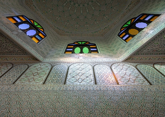 Ceiling with stained glass windows and many ornaments and details in a traditional oriental style with sun highlights