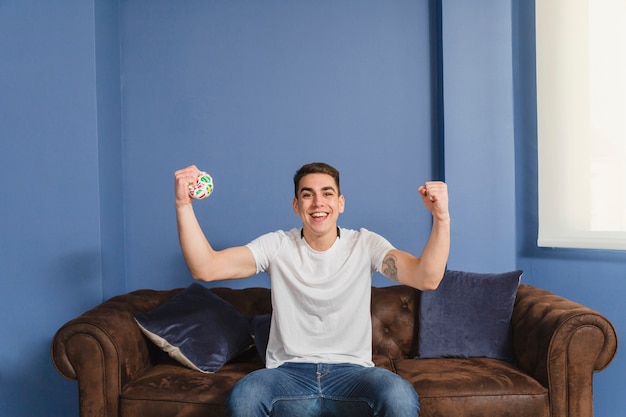 Free photo celebrating football fan on couch