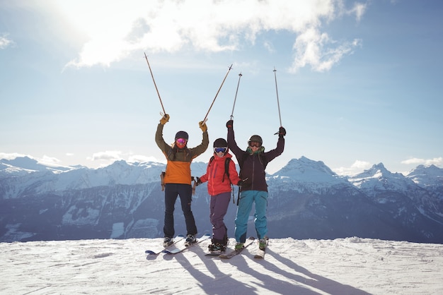 Celebrating skiers standing on snow covered mountain