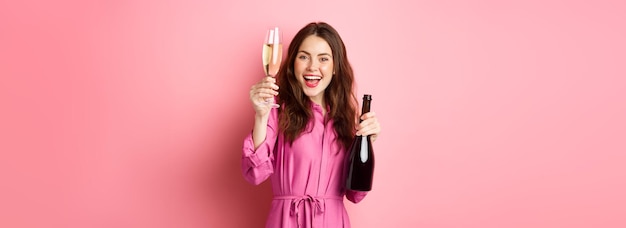 Celebration and holidays concept beautiful woman saying toast raising glass of champagne and holding