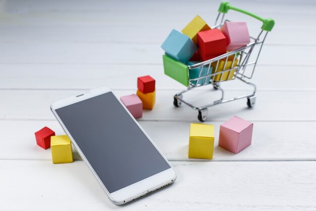 Мобильный телефон и корзина для покупок, интернет-магазины, концепция мобильной покупки