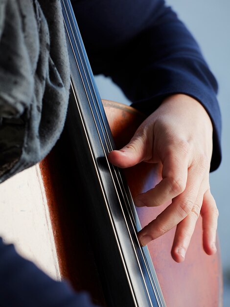 Cellist player hands. Violoncellist playing cello on background of field. Musical art, concept passion in music. Classical music professional cello player solo perform