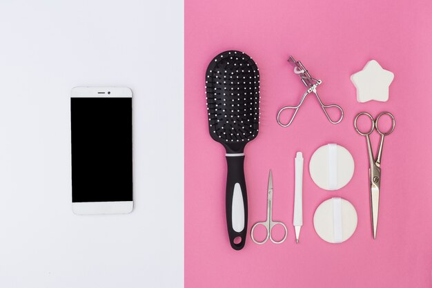 Cellphone and cuticle; hair brush; scissors; sponge; eyelash curler and sponge on dual backdrop