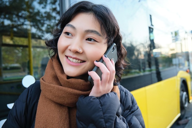 携帯電話の技術と人々 のコンセプト スタイリッシュなアジアの女の子が携帯電話で話して電話 ca