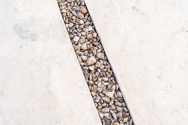 Цементный фон, пересеченный диагональной линией камня из гальки