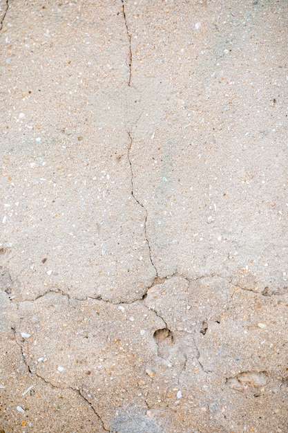 Free photo cement wall with pebbles and crack