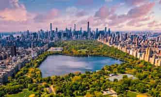 무료 사진 뉴욕 맨해튼의 센트럴 파크, 연못이 있는 마천루로 둘러싸인 거대한 아름다운 공원