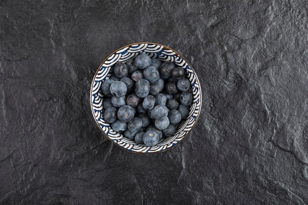 검은 표면에 맛있는 신선한 블루베리의 세라믹 그릇