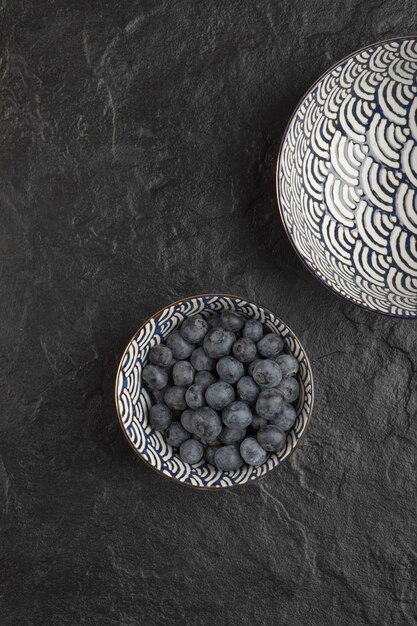 검은 표면에 맛있는 신선한 블루베리의 세라믹 그릇