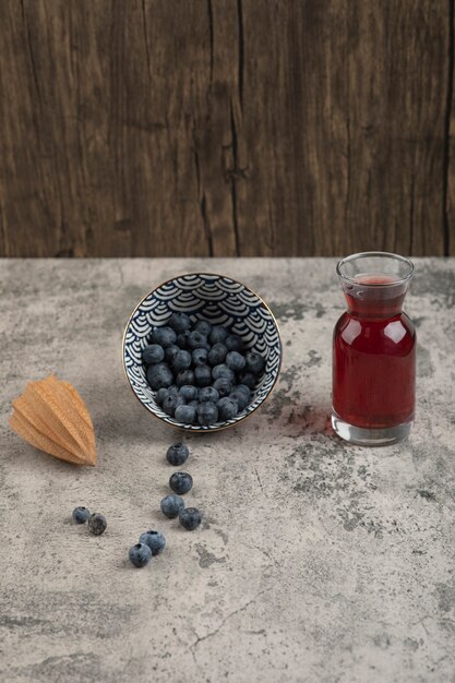 Ceramic bowl of delicious fresh blueberries and glass of juice