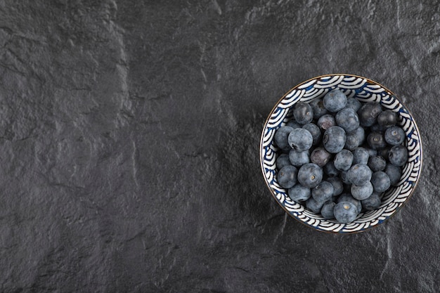 검은 표면에 맛있는 익은 블루베리의 세라믹 그릇