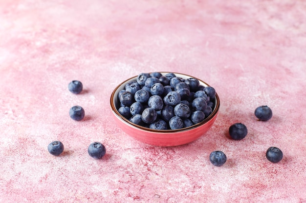 ceramic bowl of delicious ripe blueberries on marble surface