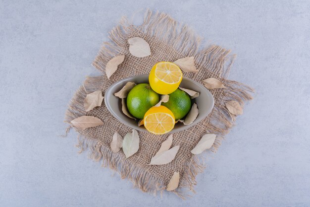 Керамическая миска свежих сочных лимонов на камне.