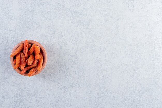 Ceramic bowl with delicious dried fruits on stone.