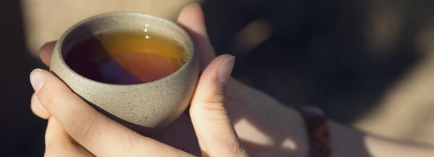 Керамические чаши из глины на деревянном фоне. девушка пьет китайский чай.