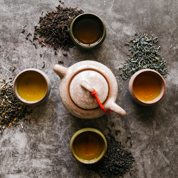 免費 Photo 陶茶,黑色背景上有乾燥的茶草和茶杯