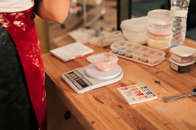 Free photo ceramic color on bowl over the measuring scale on wooden desk