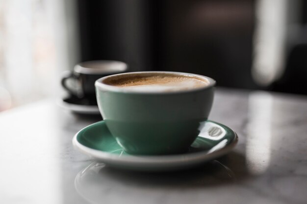 Ceramic cup of cappuccino and saucer on table