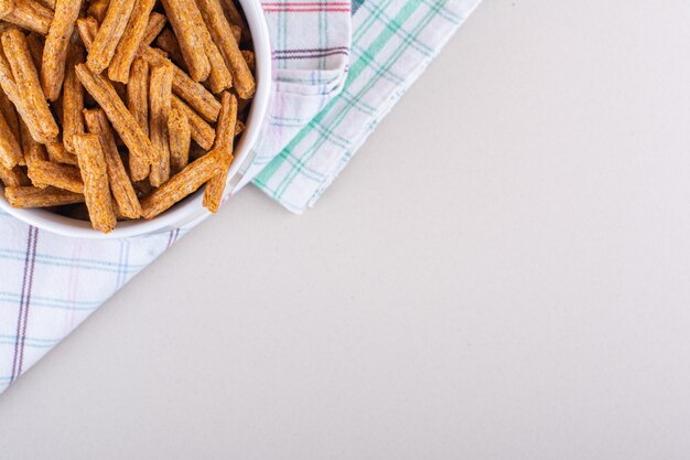 Ceramic mug of tasty crispy crackers on marble background. High quality photo