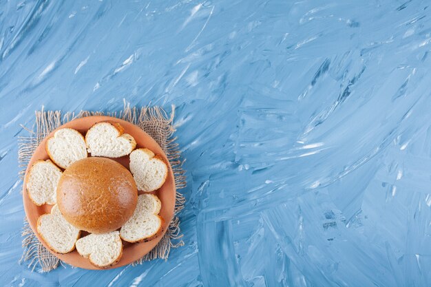 Ceramic plate of sliced white toast bread on blue surface.