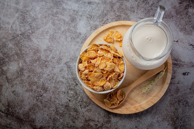 Cereal in bowl and milk on dark background