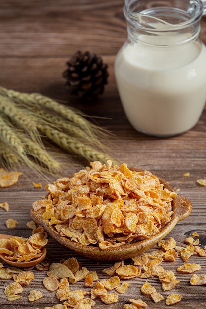 Cereal in bowl and milk on dark wooden background