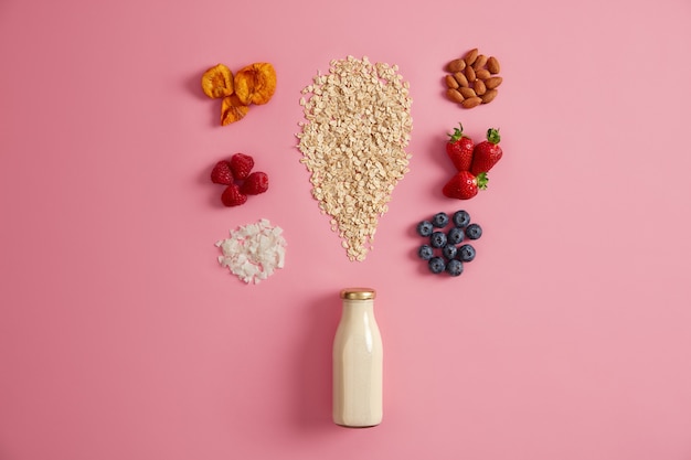 Cereal and various delicious ingredients for making morning meal. Plant based milk, oat, berries and dried fruits to make tasty porridge on breakfast. Healthy lifestyle, nutrition, fitness concept