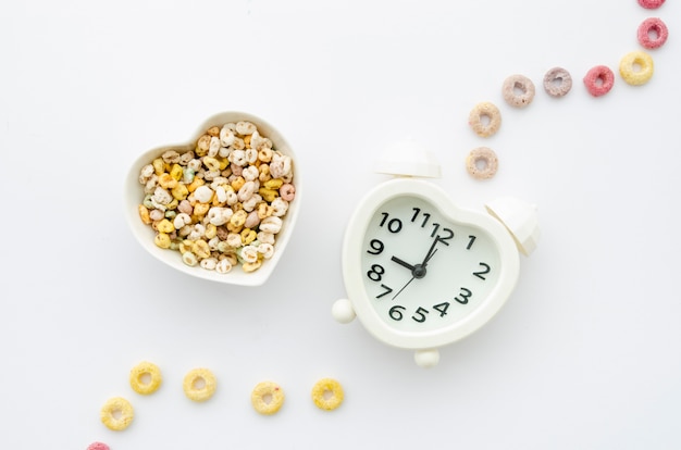 Foto gratuita cereali e orologio su sfondo bianco