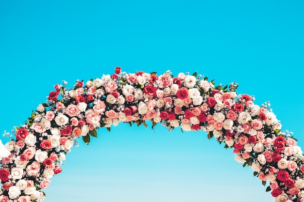 Ceremonial wedding arch on the beach decorated with natural flowers