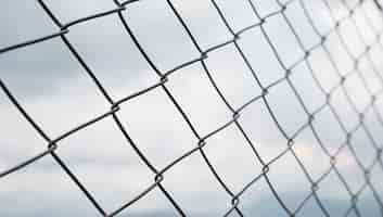 Free photo chain fence closeup against a cloudy sky protection from intrusion and restriction of freedom selective focus