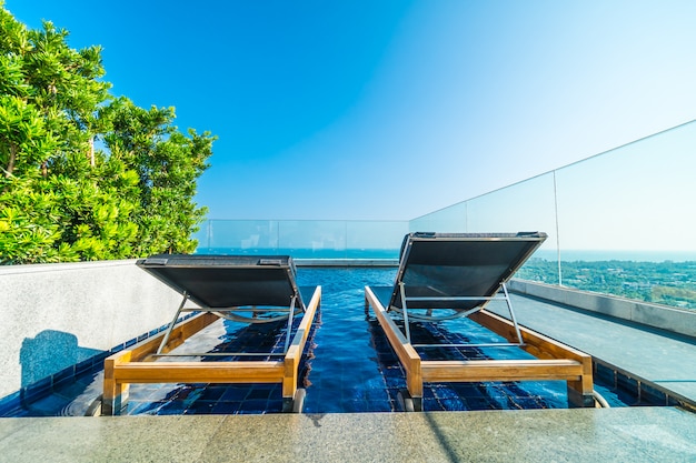 Chair and bed around swimming pool in hotel