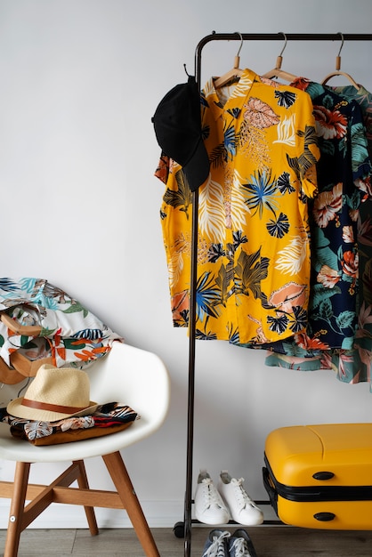 Chair and clothing rack with hawaiian shirts with floral print and hat