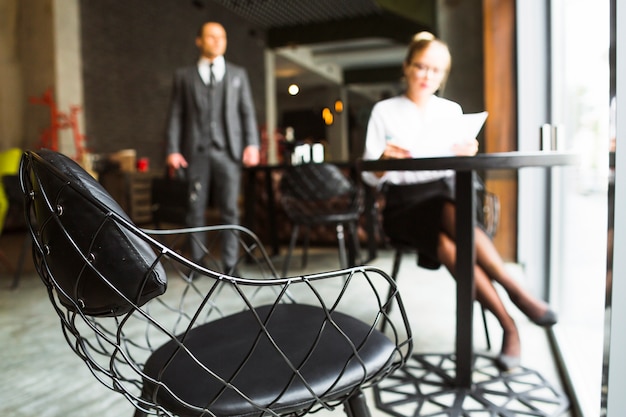 Free photo chair in front of businesswoman sitting in caf�