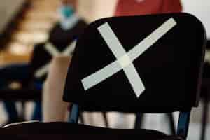 Free photo chair marked with x symbol for social distancing on a seminar in board room