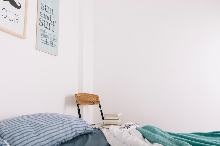 Free Photo chair with books standing near bed