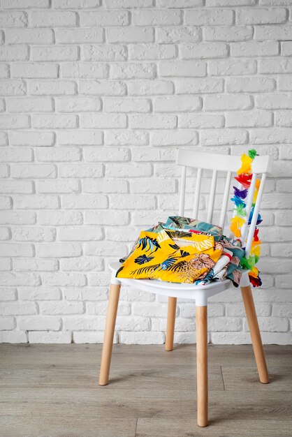 Chair with hawaiian shirts with floral print and garland