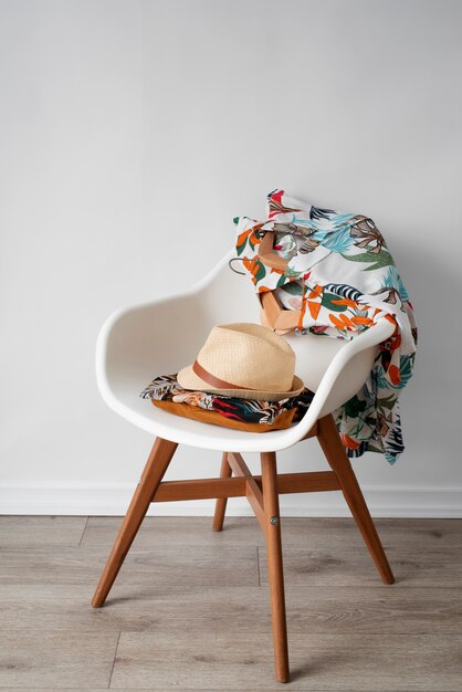 Free photo chair with hawaiian shirts with floral print and hat