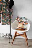 Free photo chair with hawaiian shirts with floral print and hat