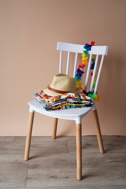 하와이안 셔츠와 모자 더미가 있는 의자