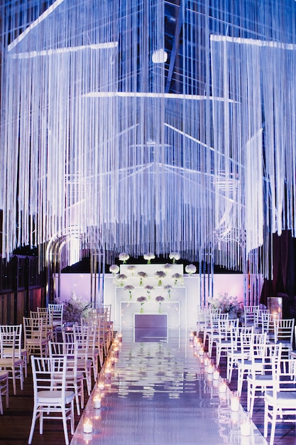 Стулья в свадебном зале и месте проведения свадебной церемонии в белом и фиолетовом цветах