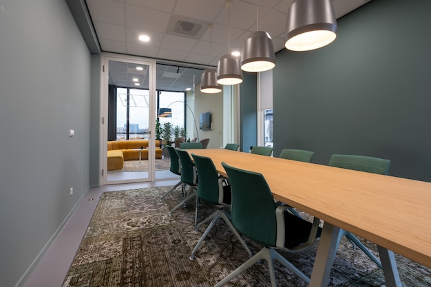 Chairs put next to a table in a room with a patterned carpet